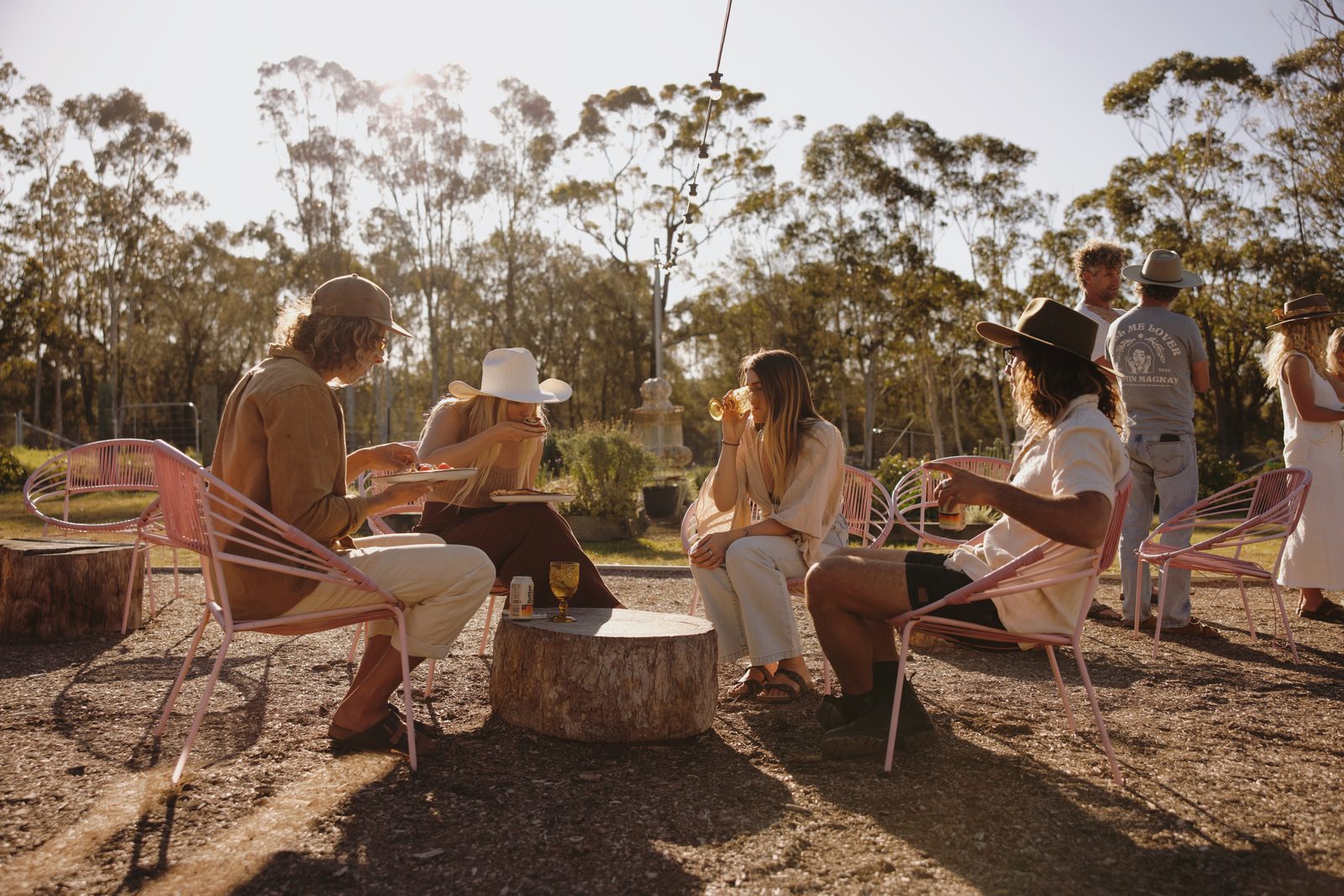 Guests on lounge chairs in the bush at golden hour
