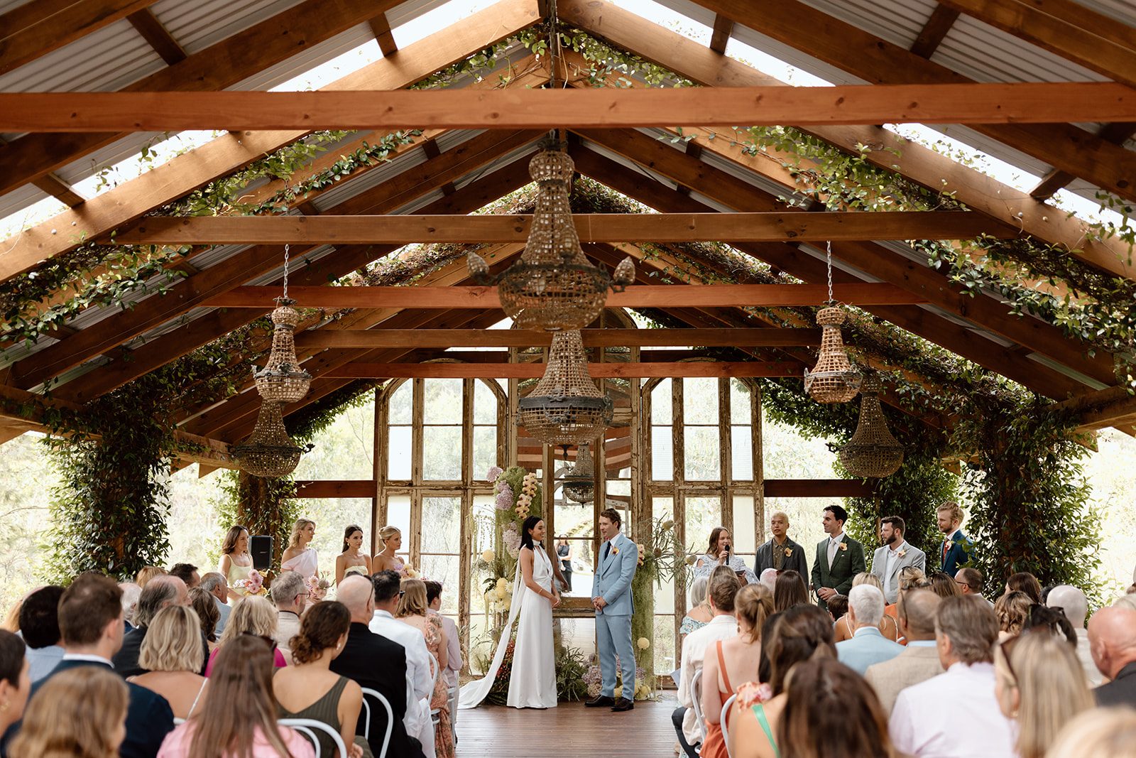 A full ceremony in the Bush Chapel seen from the back, chandeliers overhead